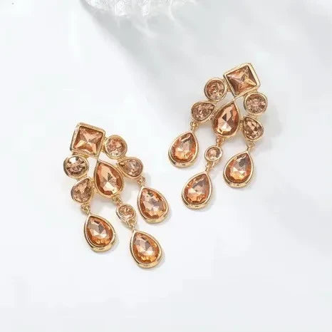 Calilo Australia gold-tone chandelier earrings with cascading teardrop and geometric crystals for formal occasions.