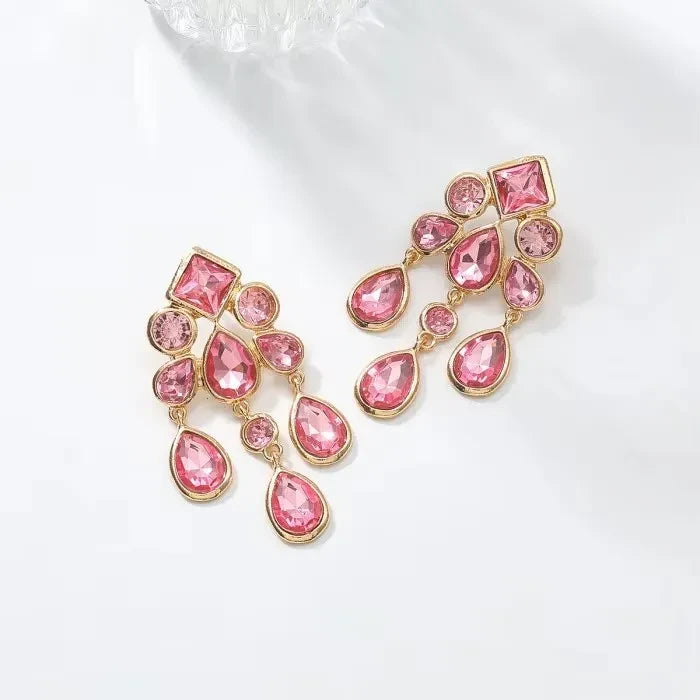 Calilo Australia chandelier drop earrings featuring pink crystals set in polished gold-tone geometric frames.
